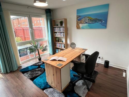 ein Büro mit einem Holzschreibtisch und einem Stuhl in der Unterkunft Spacious home near Glasgow Green in Glasgow