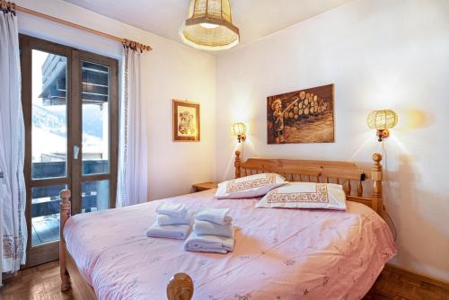 a bedroom with a large bed with two pillows on it at Ciasa Apelli in Pozza di Fassa