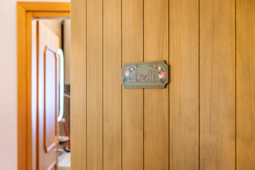 a small sign on a wooden wall at Ciasa Apelli in Pozza di Fassa