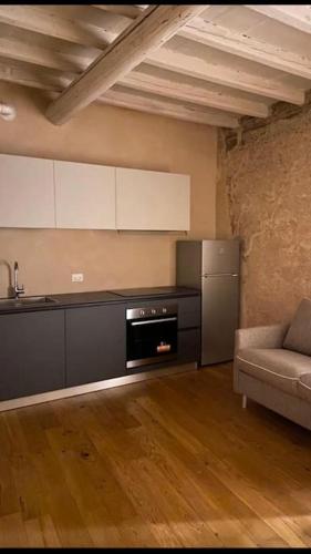 a kitchen with a refrigerator and a couch in a room at Casa Alberti in Mantova