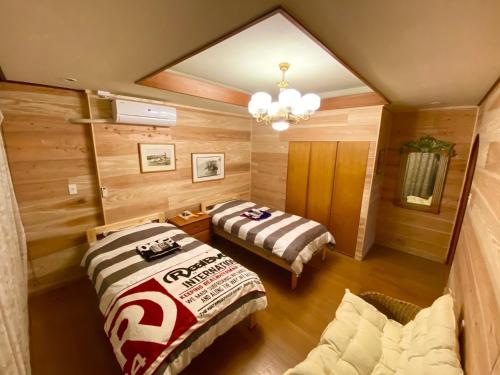 a room with two beds and a chandelier at Peakuki'i Bear's Guest House - Vacation STAY 76557v in Namihira