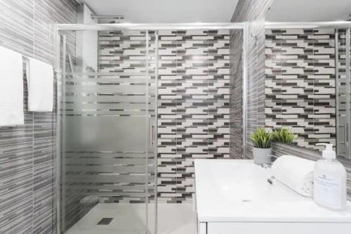 ein Bad mit einer Dusche und einem weißen Waschbecken in der Unterkunft OPO - Fantastic studio with garden in Porto