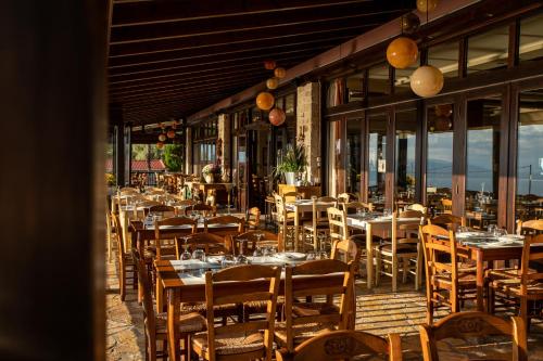 a restaurant with tables and chairs on a deck at Althaia Hotel in Thermo