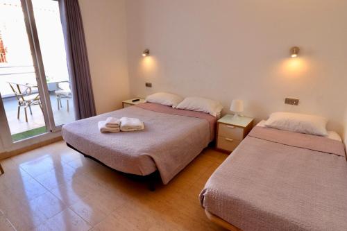 a room with two beds with towels on them at Hotel Ibiza in Sitges