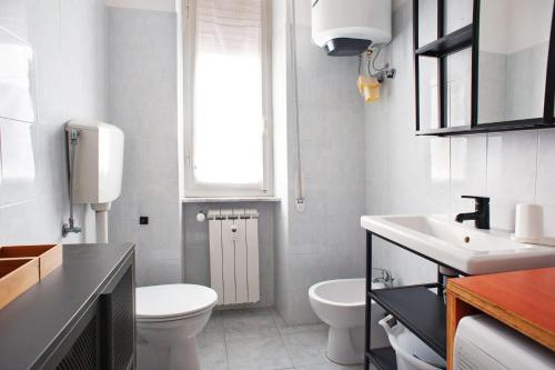 a white bathroom with a toilet and a sink at Casa Caterina in Levanto