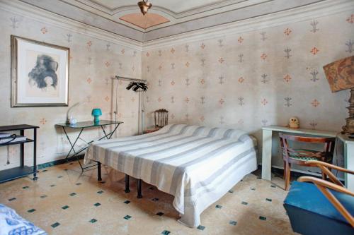 ein Schlafzimmer mit einem Bett in einem Zimmer mit Tapete in der Unterkunft Casa Alighieri 2 in Levanto