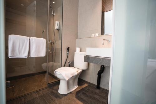 CONJIOO HOTEL at JAKARTA AIRPORT في تانغيرانغ: حمام مع مرحاض ومغسلة ودش