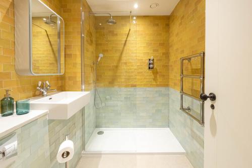 a bathroom with a sink and a shower at Three Bedroom Apartments near Spitalfields Market and Tube Station in London