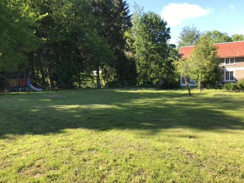 a large grass field with trees and a building at Maison d'hoursentut in Sainte-Marie-de-Campan