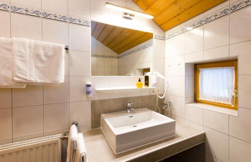 a bathroom with a sink and a mirror at Hotel Gasthof Zum Schwanen in Reutte