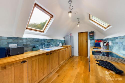 a large kitchen with wooden cabinets and a window at The Low Farm and Duddon View Barn in Broughton in Furness