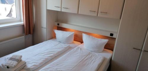 uma cama num quarto com duas almofadas em Sylter-Besserburg-App-12 em Westerland