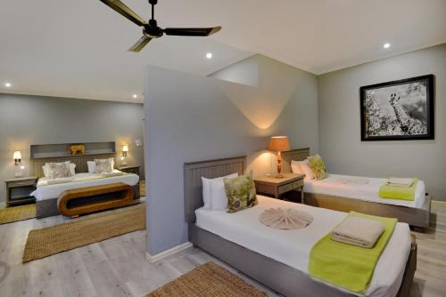 a bedroom with two beds and a living room at River View Lodge in Kasane