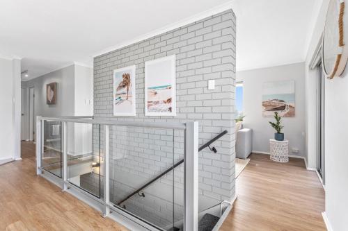 a white brick wall in a living room with a glass shelf at Freeman Retreat Yeppoon in Yeppoon