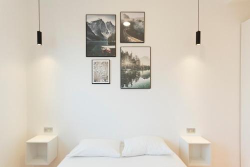 ミラノにあるArena Apartmentの白いベッドルーム(壁に絵画付)