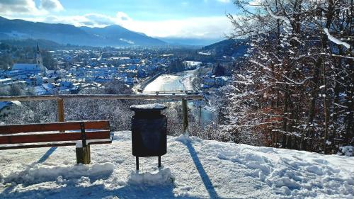 a bench with a trash can in the snow at Ferienwohnung Geierstein in Wackersberg