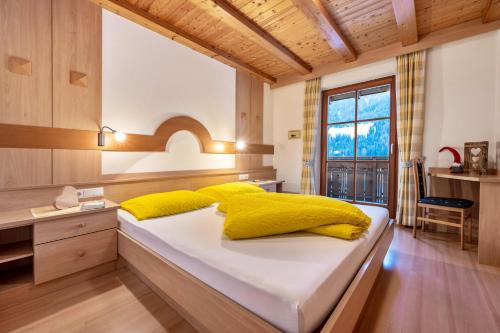 a bedroom with a large bed with yellow pillows at Niederkoflhof Wollbach in Cadipietra