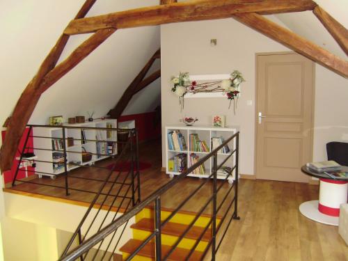 an attic room with a spiral staircase and bookshelves at Chambres d'hôtes Mauvierges in Segré