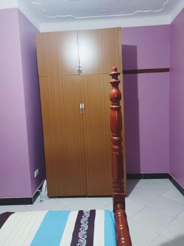 a wooden door in a room with a wooden pole at the sanctuary apartment in Namulanda