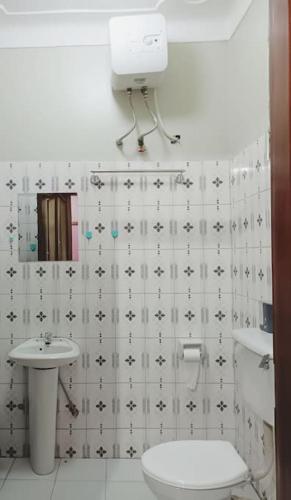 a bathroom with a toilet and a sink at the sanctuary apartment in Namulanda