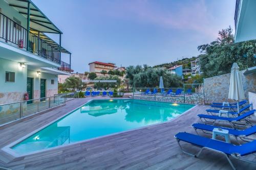 a swimming pool with lounge chairs and a hotel at Vergina Star Hotel in Nikiana