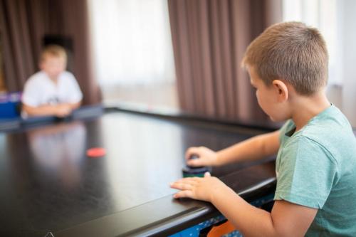 a young boy sitting at a ping pong table at Hotel Amaten in Brunico