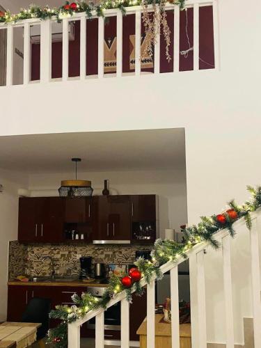 a kitchen with a staircase with christmas garland at Amarynthos Maisonettes in Amarinthos
