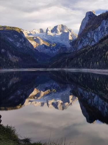 a mountain reflecting in a lake in the mountains at Ferienhaus Reiter Lotte in Gosau
