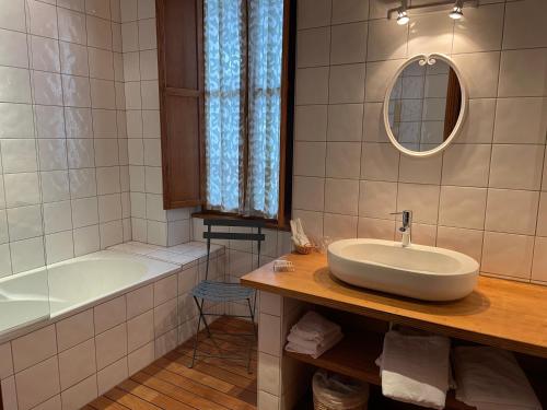 une salle de bain avec un lavabo, une baignoire et un miroir dans l'établissement Appartement 110m2, lits faits linge fourni, plein centre, WIFI, à Cauterets