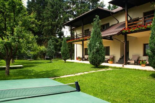 a house with a green yard with a swing at Pension Andra's House in Horezu