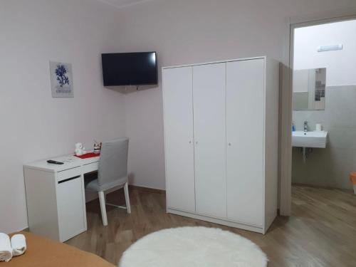een witte kamer met een bureau en een wastafel bij B&B Ranieri in Gioia Tauro
