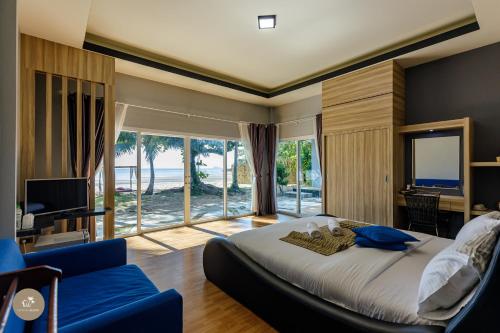 a bedroom with a large bed and a large window at Pak Nam Resort in Satun