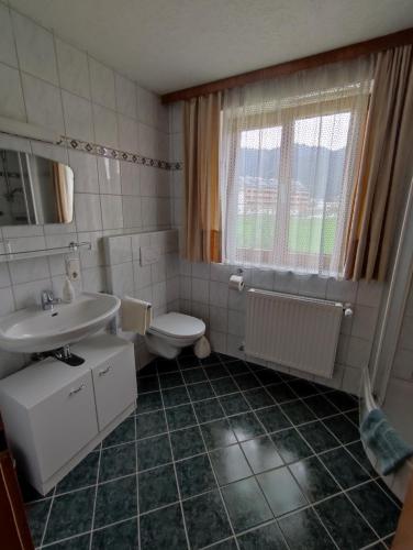 La salle de bains est pourvue d'un lavabo, de toilettes et d'une fenêtre. dans l'établissement Ferienhaus Reiter Lotte, à Gosau