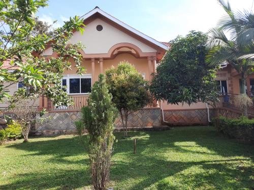 a house with trees in front of it at Airport Side Hotel Entebbe in Entebbe