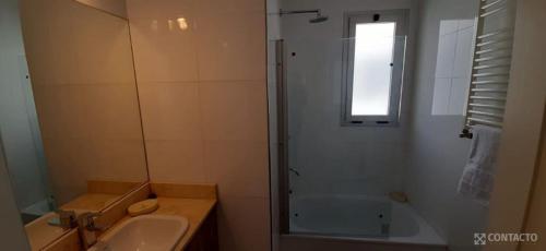 y baño con ducha, lavabo y bañera. en Departamento Alto Maipú Alquiler Temporario en Maipú