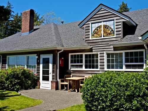 a house with a table and a cat in the window at Ecola Creek Lodge in Cannon Beach