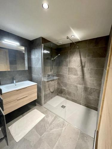 une salle de bain avec douche et lavabo dans l'établissement Appartement de standing plein centre station, 50m des pistes, aux Gets