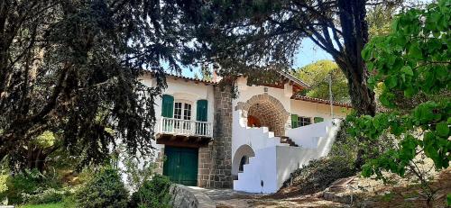 una casa blanca con una puerta verde y árboles en Casa Echevarria en Los Cocos