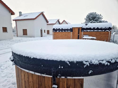 a barrel covered in snow in front of a house at Z Widokiem na Wydmę in Łokciowe