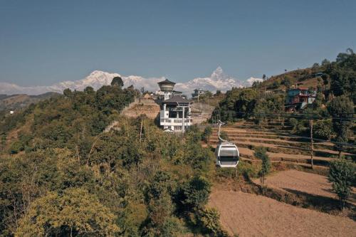 a house on the side of a hill with a van at Hotel Asia in Pokhara