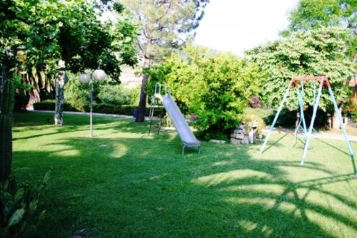 a playground with a slide in the grass at Hotel Le Rotonde in Massaciuccoli