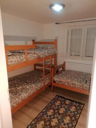 a room with two bunk beds and a rug at SIMIĆ planinska kuća in Divčibare