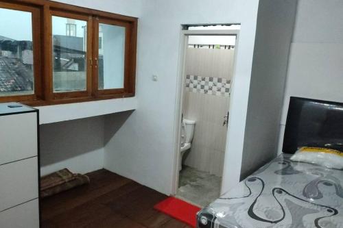 La salle de bains est pourvue de toilettes, d'une fenêtre et d'une télévision. dans l'établissement Kost or Pasutri Rooftop Pogung Dalangan Sleman, à Kejayan