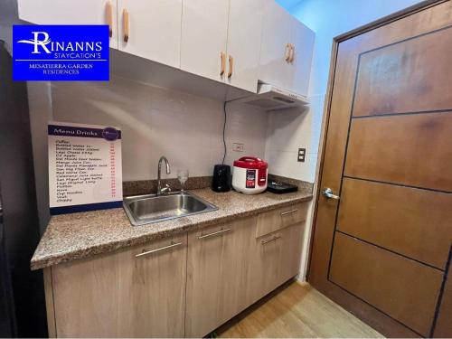 a small kitchen with a sink and a door at Rinann's Staycation 1021 Mesatierra Condotel Davao in Davao City