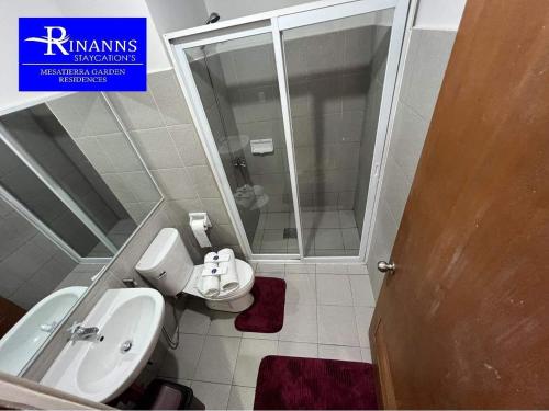 a bathroom with a toilet and a sink and a shower at Rinann's Staycation 1021 Mesatierra Condotel Davao in Davao City
