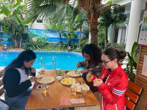 un grupo de mujeres sentadas en una mesa comiendo comida en Tam Coc Full House Homestay, en Ninh Binh