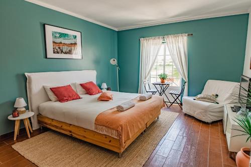 1 dormitorio con paredes azules y 1 cama con almohadas rojas en In My House Baleal en Baleal
