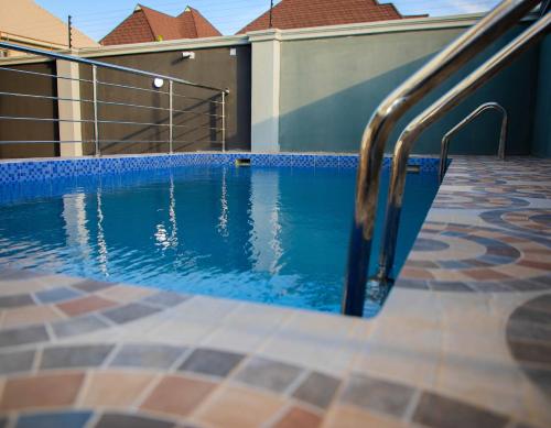 a swimming pool with a metal hand rail next to a building at Delight Apartments in Lagos