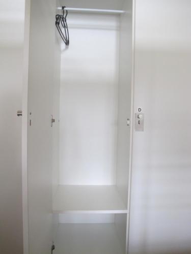 a white closet with a door and a curtain at Azores Youth Hostels - Sao Miguel in Ponta Delgada