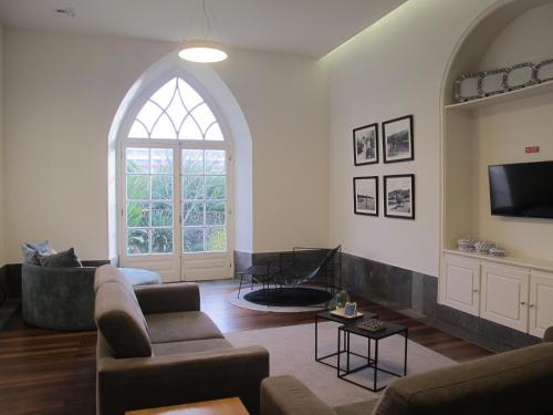 a living room with a couch and a tv at Azores Youth Hostels - Sao Miguel in Ponta Delgada